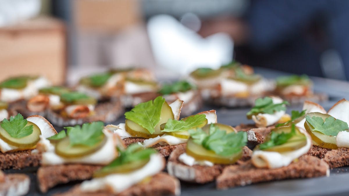 Close-up of open-faced sandwiches with pickles and parsley, perfect for lunch.
